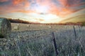 Sunset over farm field with hay bales Royalty Free Stock Photo