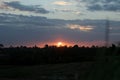 Sunset over the field. Peeking the sun down behind the grass. Sunset sunrise backgrounds. Abstract nature background.