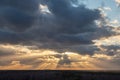 Sunset over the forest with sun rays breaking through clouds Royalty Free Stock Photo