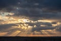 Sunset over the forest with sun rays breaking through clouds Royalty Free Stock Photo