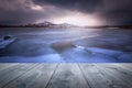 Sunset over frozen lake with empty wooden table. Natural template landscape Royalty Free Stock Photo