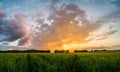 Sunset over green field with road Royalty Free Stock Photo