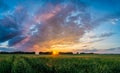 Sunset over green field with road Royalty Free Stock Photo