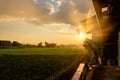 Sunset over the greeny farmland at the old wooden farmland, Sunbeams through the cloud as a sunset