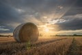 Sunset over a harvested cornfield with straw bales Royalty Free Stock Photo