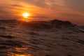Sunset over horizon line in sunset with ripples wave ocean wave low angle view. Close up Nature background