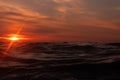 Sunset over horizon line in sunset with ripples wave ocean wave low angle view. Close up Nature background