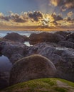 Sunset over the horizon of the ocean with a rocky shoreline in Sao Martinho do Porto, Portugal Royalty Free Stock Photo