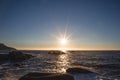 Sunset over the horizon with rocks in the water Royalty Free Stock Photo