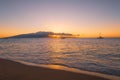 Sunset over island, sailboats, and sandy beach in Maui Royalty Free Stock Photo