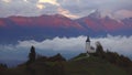 Sunset over Jamnik, Slovenia. Rainbow, Alps and Church of St. Primoz, aerial drone view