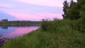 Sunset over the lake. Pink clouds lit by the setting sun. Calm and pacification of nature