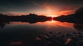 Sunset over the lake with reflection of mountains in the water. Royalty Free Stock Photo