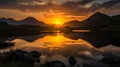 Sunset over a lake with reflection in the water and mountains in the background Royalty Free Stock Photo