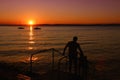 Sunset over the lake with ships and people silhouettes Royalty Free Stock Photo