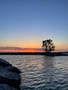 Sunset over the lake with silhouettes of trees and clouds in the sky. Royalty Free Stock Photo