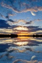 Sunset over the lake on a sky background with planets Royalty Free Stock Photo