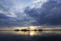 Sunset over the lake on a warm summer day. June sky and beautiful clouds. Horizon and reflection.