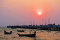 Sunset over the long bridge and boats at the sea. Royalty Free Stock Photo