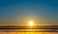 Sunset over a majestic cloudscape with warm orange and yellow colors.