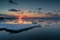 Sunset over the mirror surface of the sea, in which blocks of ice float Royalty Free Stock Photo