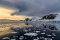 Sunset over the mountains and drifting icebergs at Lemaire Strait, Antarctica