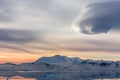 Sunset over the mountains with glaciers and drifting icebergs at