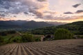 Sunset in a valley surrounded by mountains and green meadows