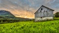 Sunset over mountains and old barn in norway Royalty Free Stock Photo