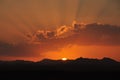 Sunset over mountains with tree with sun shining through clouds mountains clouds