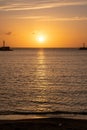 Sunset over Mykonos island, Cyclades, Greece. Lighthouse, orange yellow sky sparkle sea. Vertical