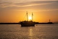 Sunset over Mykonos island, Cyclades, Greece. Moored ship at port, beacon orange sky sparkle sea Royalty Free Stock Photo