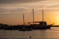 Sunset over Mykonos island, Cyclades, Greece. Moored ship at port, beacon orange sky sparkle sea Royalty Free Stock Photo