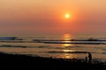 Coastal sunset with family of one adult and one small child in silhouette Royalty Free Stock Photo