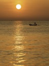 Sunset over ocean with small fishing boat silhouette on sea Royalty Free Stock Photo