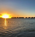 Sunset Over the Ocean: Sunset on Jamaica`s west coast with over-the-water bungalows silhouetted against the amazing sun Royalty Free Stock Photo