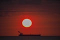 Setting sun behind a ship - Sunset over the ocean Curacao Views Royalty Free Stock Photo