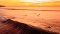 Sunset over ocean waves with surfers and bright sky Royalty Free Stock Photo