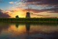 Sunset over an old dutch windmill by a river in Kinderdijk, Netherlands Royalty Free Stock Photo