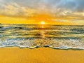 Kauai\'s Sunset Radiance: Golden Shore, Foamy Waves, and Turquoise Waters Royalty Free Stock Photo