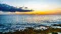 Sunset over the Pacific Ocean with waves crashing on the Rocky Shoreline under colorful sky Royalty Free Stock Photo