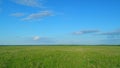 Sunset over an pasture field. Green field of grass and blue sky on farm. Time lapse. Royalty Free Stock Photo