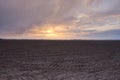 Sunset over a plowed agricultural field. Dramatic sky in the evening