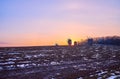 The sunset over the plowed snowy field with timber windmills on horizon, Pyrohiv Skansen, Kyiv, Ukraine