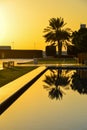 Sunset over pool with palm trees Royalty Free Stock Photo