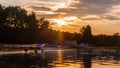 Sunset over the recreational lake, you can see ducks and boats. Beautiful orange colors, big contrast. Holidays and rest. Royalty Free Stock Photo