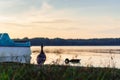 Sunset over the recreational lake, you can see ducks and boats. Beautiful orange colors, big contrast. Holidays and rest. Royalty Free Stock Photo