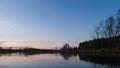 Sunset over the river, clouds are reflected in wa