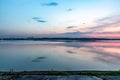 Sunset over the river reservoir sea in pink and blue shades. View of the opposite shore. Horizontal orientation. Royalty Free Stock Photo