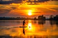 A sunset over a river, silhouetting a lone paddleboarder Royalty Free Stock Photo